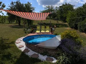 a swimming pool with chairs and a hammock over it at Cseligevi Vendégház in Szekszárd