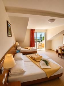 two beds in a hotel room with a window at Hotel Neptun Gradac in Gradac +34 photos