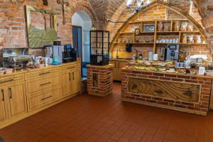a kitchen with wooden cabinets and a brick wall at Soul House Gdansk Old Town in Gdańsk