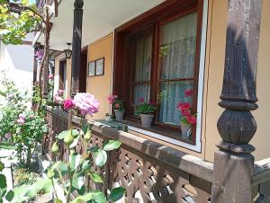 a porch of a house with potted plants and a window at Guest Rooms Dona in Koprivshtitsa