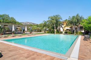 a pool at a resort with chairs and umbrellas at Stanze in Sykelgrima in Castelforte