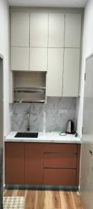 a kitchen with white cabinets and a sink at Sufi Idaman Studio for Islamic only in Nilai