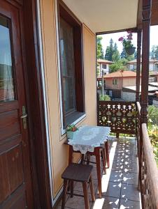 a table and chairs on the balcony of a house at Guest Rooms Dona in Koprivshtitsa +22 photos