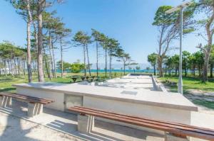 a group of benches in a park with trees at Apartman Natalija in Privlaka