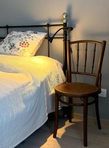 a wooden chair next to a bed with a pillow at Riverside Furth in Furth