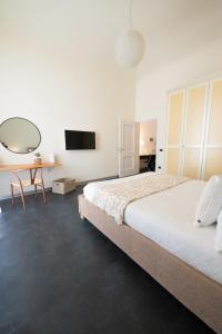 a bedroom with a bed and a table and a tv at Dimora Altea in Taranto