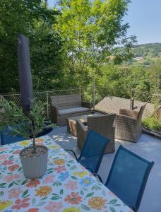 a table with chairs and a potted plant on a patio at Résidence La Rose in La Bourboule