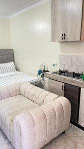 a living room with a couch in front of a kitchen at Muyenga Studio Apartments in Kampala