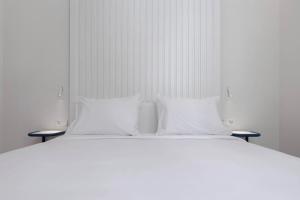 a large white bed with two pillows on it at SLEEP'N Valencia in Valencia