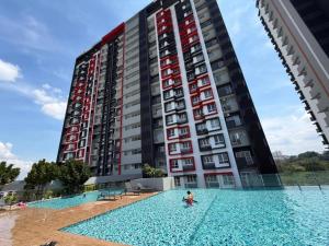 a person in a swimming pool in front of a tall building at Sufi Idaman Studio for Islamic only in Nilai