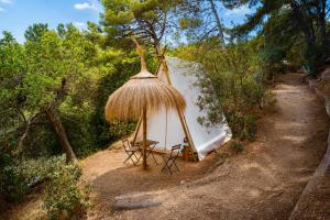 a tent with a table and chairs in the woods at Kampaoh Tossa de Mar in Tossa de Mar