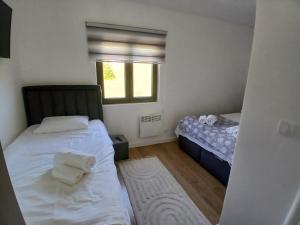 a small bedroom with two beds and a window at Vila Golijat in Raška