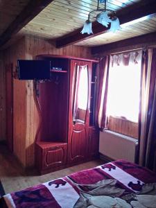 a room with a bed and a wooden door and windows at U Karoliny in Yaremche