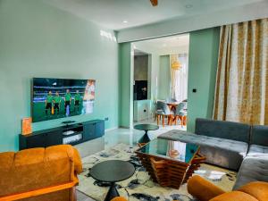 a living room with a couch and a tv at Matemwe Bluu Villa in Matemwe