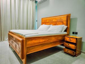a wooden bed with a wooden headboard and a night stand at Matemwe Bluu Villa in Matemwe +86 photos
