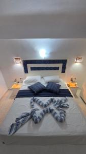 a large bed with blue and white sheets and pillows at Villa Dar La Belle Beyah - Tezdaine in Taguermess +18 photos