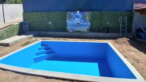 a blue swimming pool in the middle of a yard at Fantastic house in Aldeia Nova