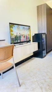 a flat screen tv sitting on top of a entertainment center at Muyenga Studio Apartments in Kampala