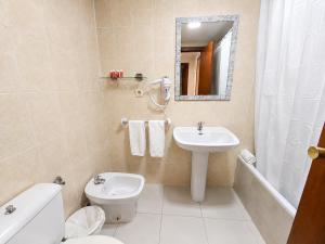 a bathroom with a sink and a toilet and a mirror at Luxmar Apartaments By MC in Benidorm +4 photos