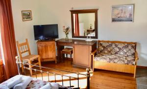 a living room with a tv and a couch and a desk at Saily Beach Hotel in Koropi