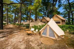 a row of tents with chairs and a table at Kampaoh Bayona Playa in Baiona