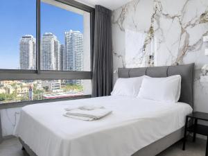 a bedroom with a white bed with a large window at C Tower Apartments in Netanya +291 photos