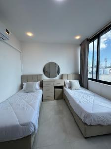 two beds in a room with a mirror at Amman Suites in Amman