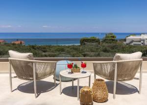 a patio with two chairs and a table with drinks at Ark Luxury Suite, Hot tub & Sea Views, by ZanteWize in Tragaki +58 photos