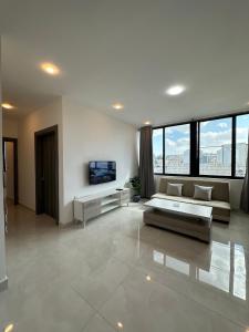 a large living room with a couch and a tv at Amman Suites in Amman
