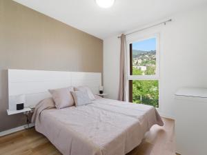 a white bedroom with a large bed and a window at Virginia N214 2P4 in Grasse