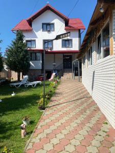 a house with a brick walkway in front of it at Casa Valex in Tohanu Nou
