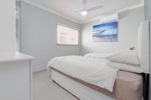 a white bedroom with a bed and a window at Vallen Lodge 2 in Ballito +14 photos