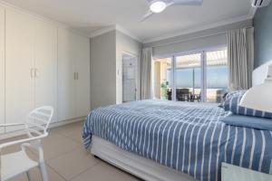 a bedroom with a blue and white bed and a balcony at Vallen Lodge 2 in Ballito
