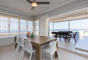 a dining room with a table and chairs and a piano at Vallen Lodge 2 in Ballito