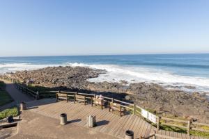 a view of the beach with benches and the ocean at Vallen Lodge 2 in Ballito