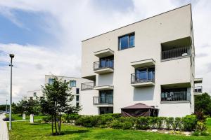 an apartment building with balconies and a tree at Victory port Apartmán in Liptovský Mikuláš