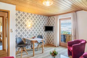 a living room with a table and chairs and a window at Ferienwohnung Panorama Bad Kohlgrub in Bad Kohlgrub