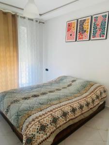 a bed in a white room with a window at Staycation Yakout in Mansouria +2 photos
