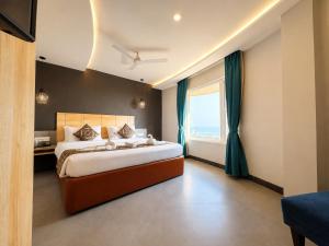 a bedroom with a large bed and a large window at Hotel Prabhu Pada Puri - Beach Front Hotel With Swimming Pool And Restaurant - SPA- Banquet - Parking Facility in Puri +38 photos