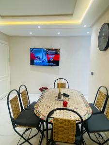 a table with chairs and a television in a room at Staycation Yakout in Mansouria