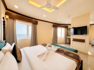 a bedroom with a bed with a view of the ocean at Hotel Prabhu Pada Puri - Beach Front Hotel With Swimming Pool And Restaurant - SPA- Banquet - Parking Facility in Puri