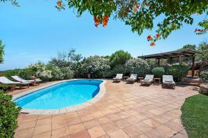 a swimming pool with lounge chairs and a gazebo at Villa Sardinia Costa Smeralda in Arzachena
