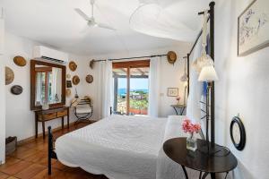 a bedroom with a bed and a table and a window at Villa Sardinia Costa Smeralda in Arzachena +25 photos