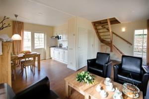 a living room with a table and chairs and a kitchen at Erve Woolderink in Wierden +41 photos