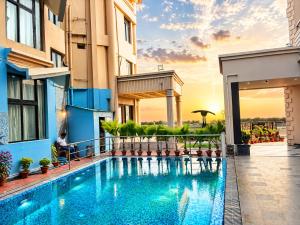 a hotel swimming pool with the sunset in the background at Hotel Prabhu Pada Puri - Beach Front Hotel With Swimming Pool And Restaurant - SPA- Banquet - Parking Facility in Puri
