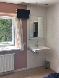 a bathroom with a sink and a window at Bungalow Halfweg in Ballum