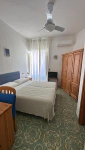 a bedroom with two beds and a ceiling fan at Villa Egidio Terrazza in Sant'Angelo D'Ischia
