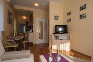 a living room with a couch and a tv on a wall at Iva 1, wonderful view of Kvarner Bay in Opatija