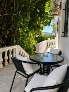 a patio with a table and chairs on a balcony at Studios Annie in Bijela