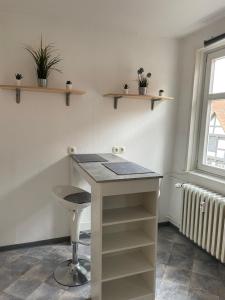 a room with a table and a stool and shelves at Fluss-Bett in Melsungen